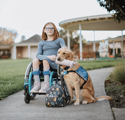 Young girl in her wheel chair and her service dog
